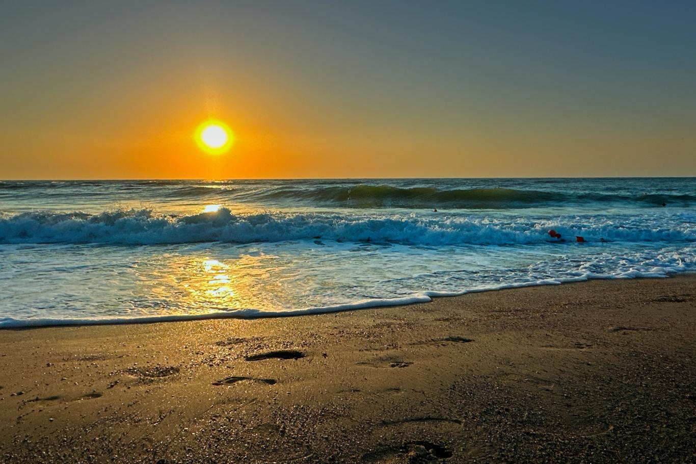 Răsărit spectaculos de soare portocaliu reflectat pe apele liniștite ale Mării Negre