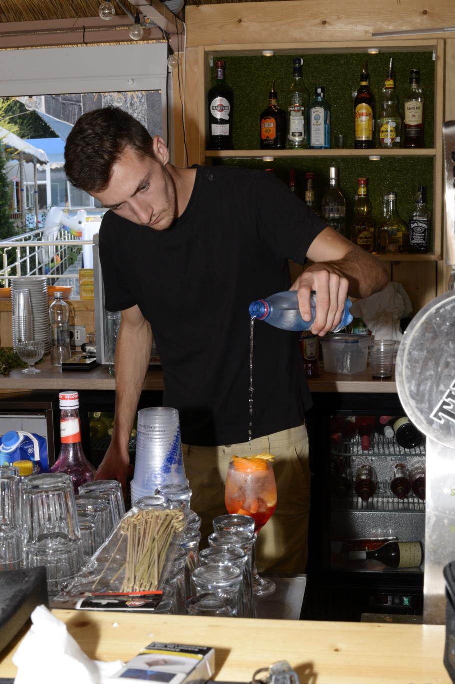 Barman pregătind băuturi la barul restaurantului Hotel Hercules