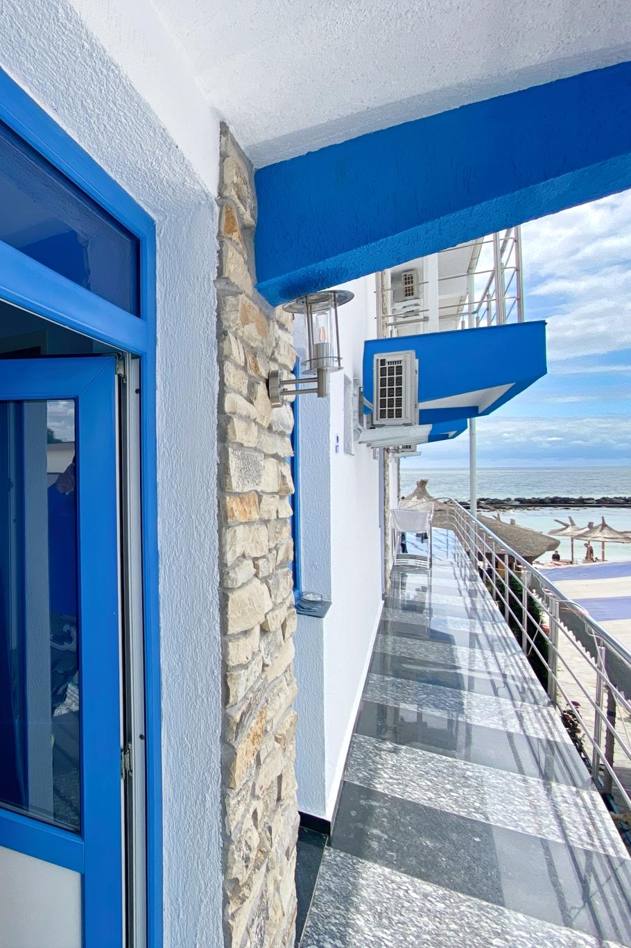 Coridor exterior al Hotel Hercules cu balustradă argintie și vedere la mare