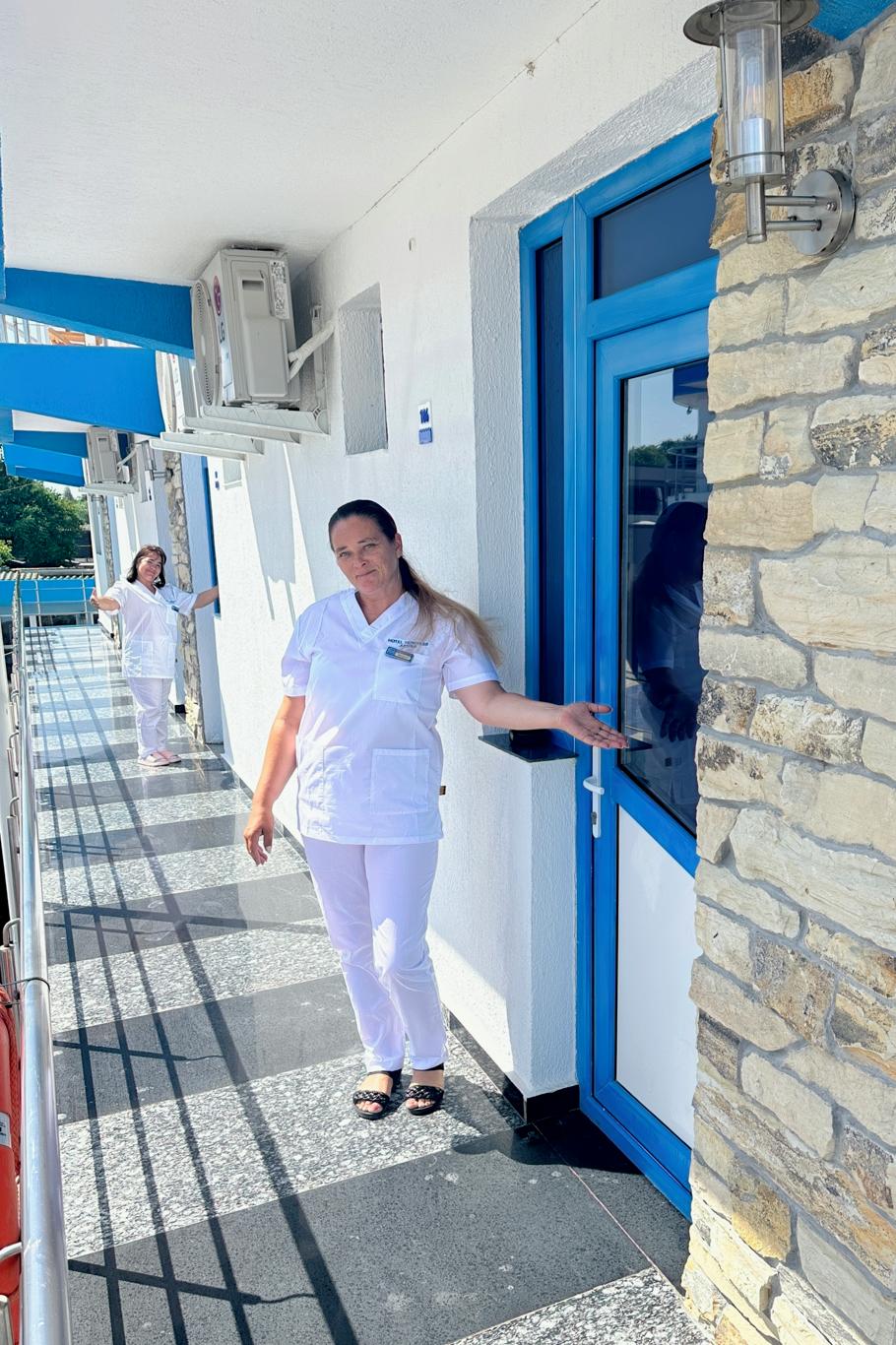 Membrii ai personalului în uniformă albă pe coridorul exterior al Hotelului Hercules