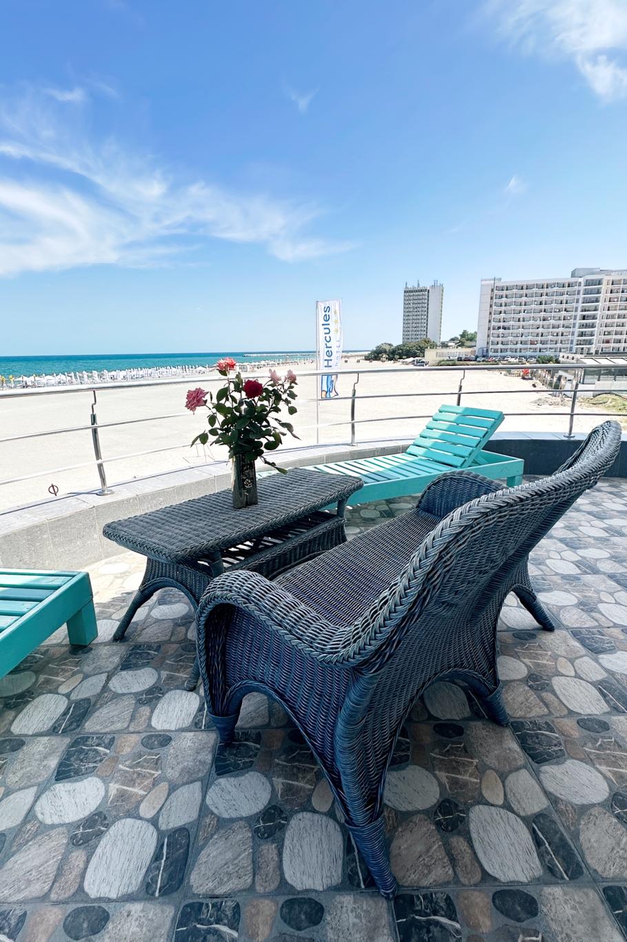 Terasă cu mobilier din răchită și flori, cu vedere panoramică la Marea Neagră și orizont larg