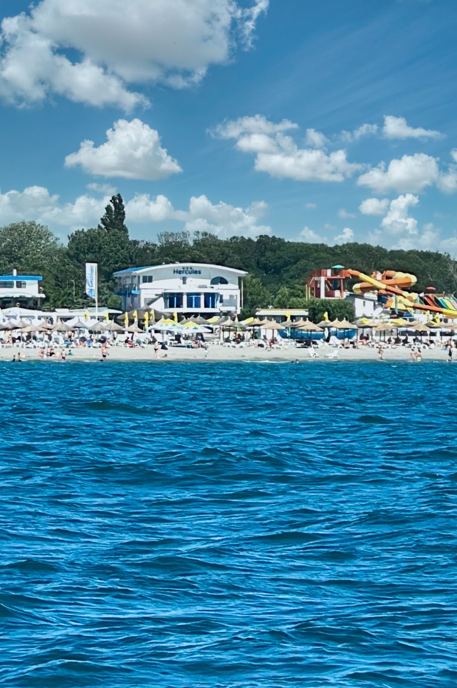 Vedere din Marea Neagră cu plajă animată și apă albastră pe Hotel Hercules
