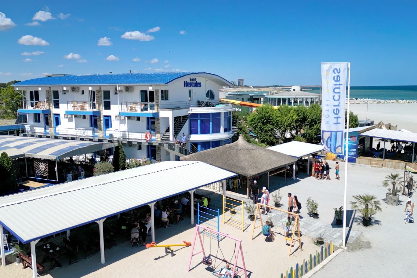 Vedere aeriană a întregului complex Hotel Hercules cu terase acoperite, grădini și plajă